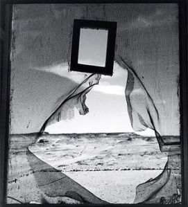 Lee Miller - Retrato del espacio (1937) - La imagen está tomada desde el interior de una tienda de campaña desde la que se ve una mosquitera rota en su centro, un espejo con marco de madera colgado del techo y afuera, la inmensa extensión del desierto. Pulse para ampliar.